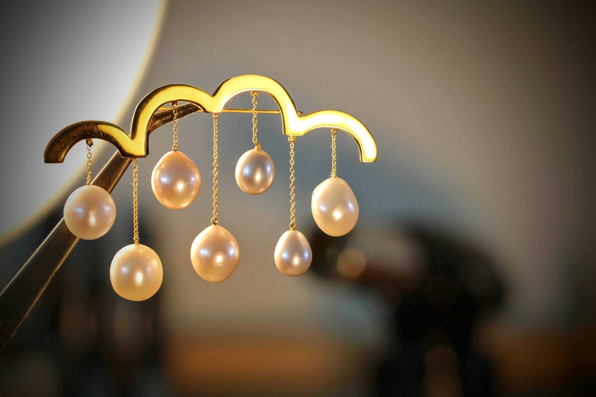 Spring Brooch van Olivia Peeters Master Goldsmith: Een delicate goudkleurige broche in de vorm van een wolk, met hangende parels die regendruppels voorstellen. Het ontwerp symboliseert de frisheid en bloei van de lente, met een speelse en elegante uitstraling.